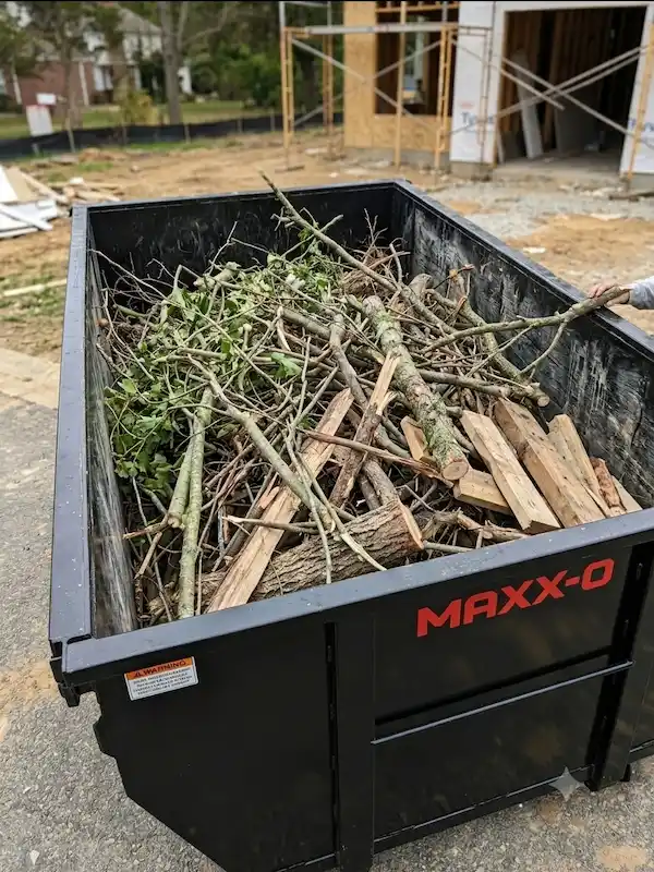 Roll-off dumpster on a tree-lined property